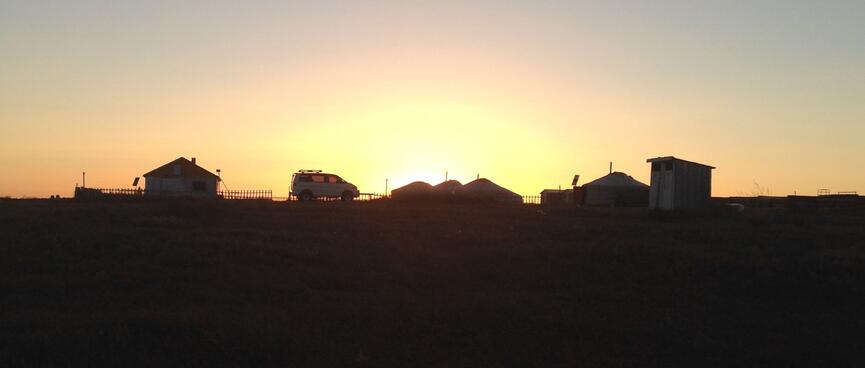 The shapes of buildings and our van against the setting sun.