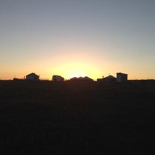 The shapes of buildings and our van against the setting sun.