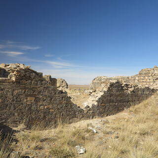A v-shaped hole in a tall stone wall.