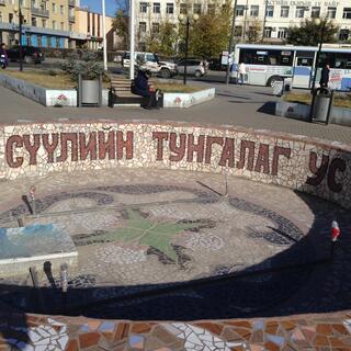 A tiled pond features the Cyrillic text ʼСУУЛИЙН ТУНГАЛАГ УС МЗТʼ.