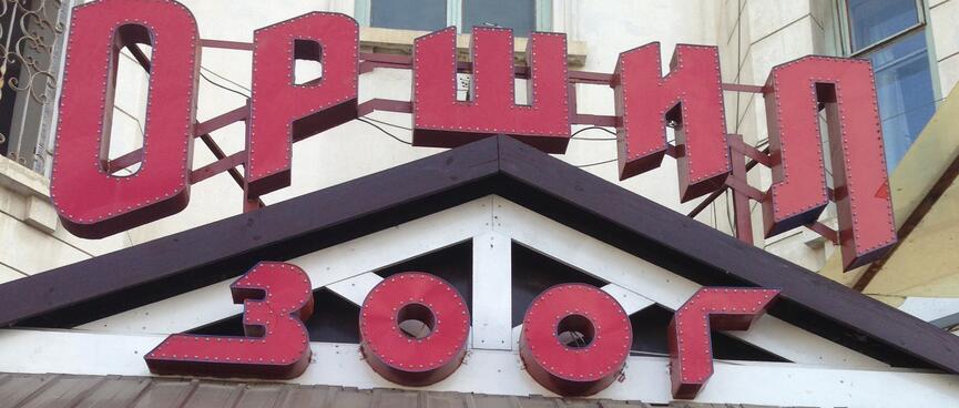 Stylised red lettering above the tiled doorway of a coffee shop.