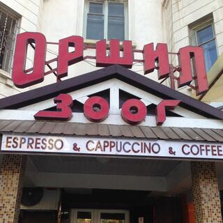Stylised red lettering above the tiled doorway of a coffee shop.