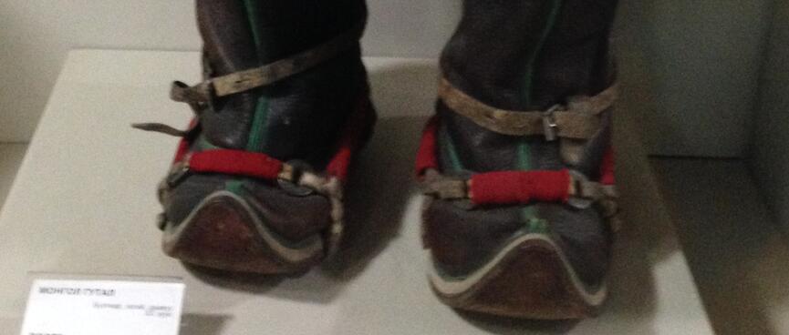 A pair of felted boots are black red and brown, with stitched red liners.