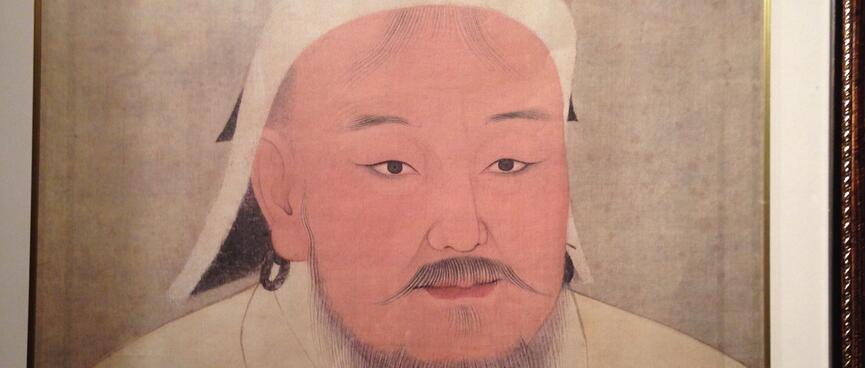 A man wearing a white shirt and hat, with a pink complexion and a brown moustache and goatee beard.