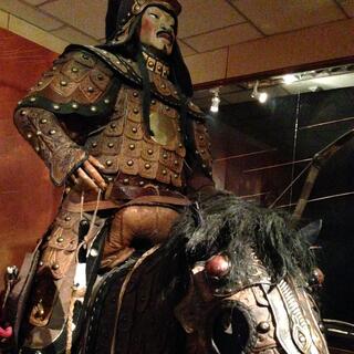 A soldier wearing armour sits on top of an armoured horse.