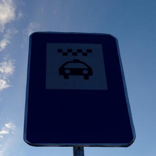 A rectangular sign displays a taxi icon.