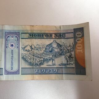An assembled ger being drawn by a large team of cattle, on the back of a 1000 Tugrik bill.