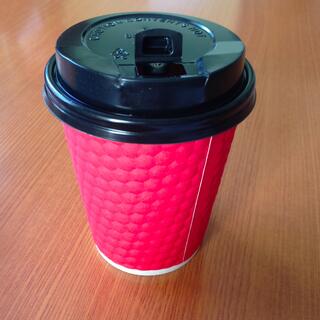 A red paper cup with a black plastic lid.