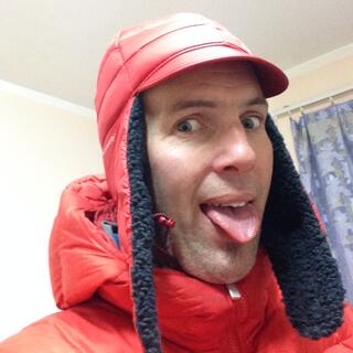 Wearing a red hat with long ear flaps and sticking my tongue out like a dog.