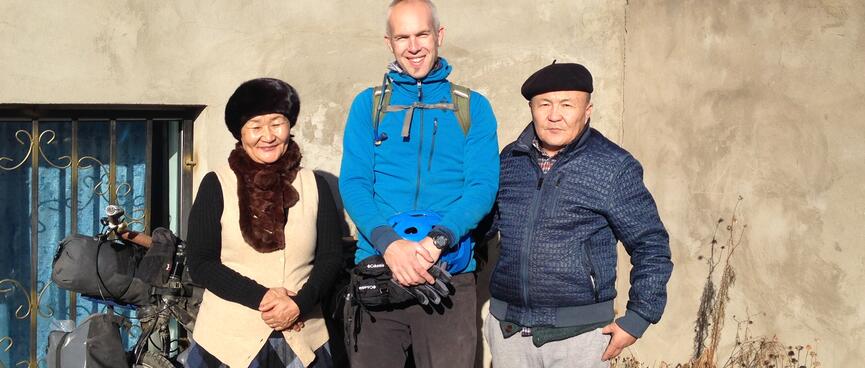 A smiling woman and a serious man stand either side of me, both wear berets and are somewhat shorter than me.