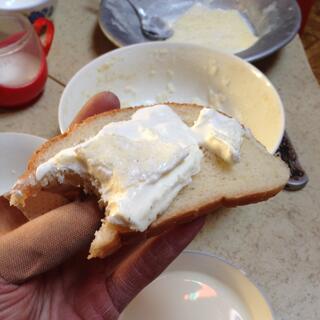 Soft yellow cheese with a white outer, spread onto a slice of bread.