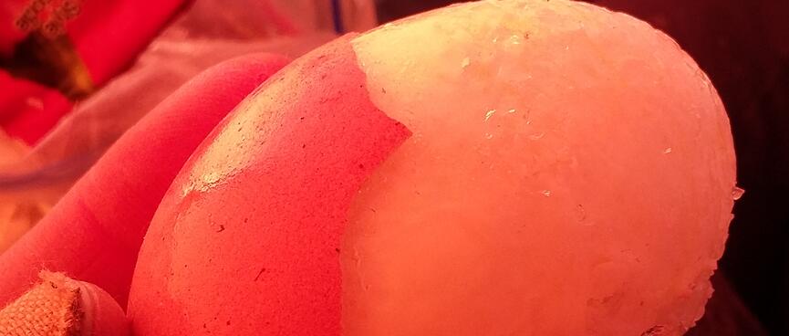 The frozen white of a partially shelled boiled egg.