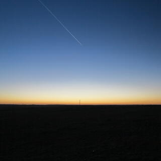 Blue sky and an orange strip above the black horizon.