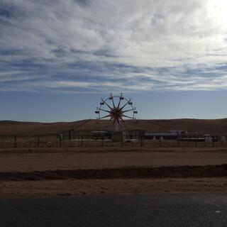 A round ferris wheel with empty chairs.