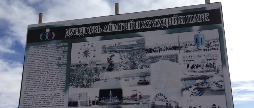 A black and white billboard shows the various fairground rides in action.