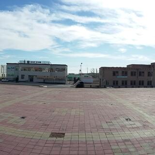 A red brick town square covered in yellow grid lines and repeating motifs. 