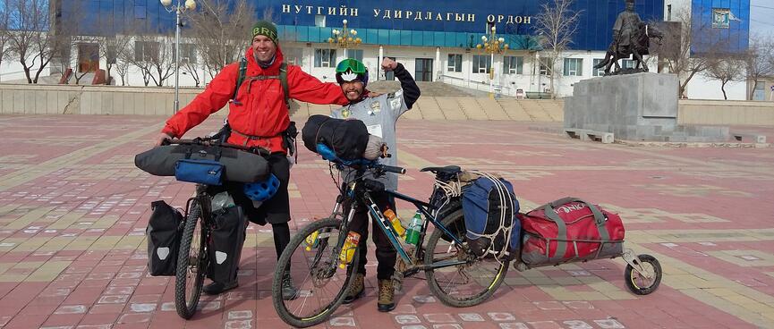 Two cyclists posing with their loaded bicycles.