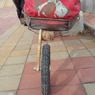 A mono wheel trail holds a red pack.