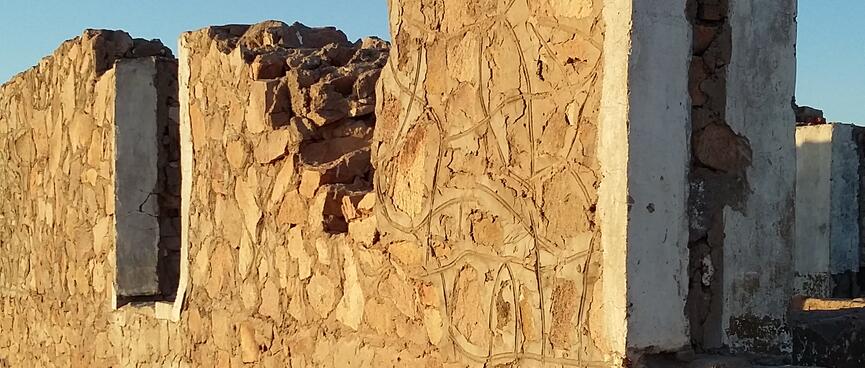 The buildingʼs walls contain angular mud bricks inscribed in swirling patterns.
