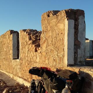 The buildingʼs walls contain angular mud bricks inscribed in swirling patterns.