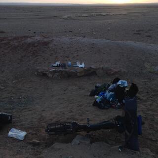 Cooking gear is laid out in a sandy shallow.