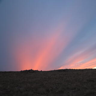 Pink and blue streaks extend from the horizon.