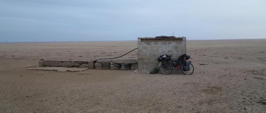 A small brick shed and a long trough to its left.