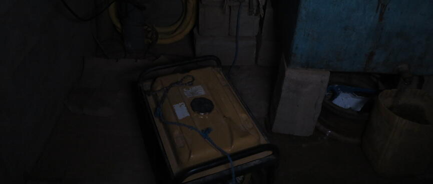 A dark room. A yellow diesel pumop is barely visible.