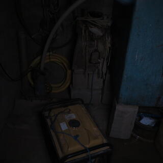 A dark room. A yellow diesel pumop is barely visible.