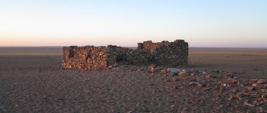 The damaged brick walls of a square building.