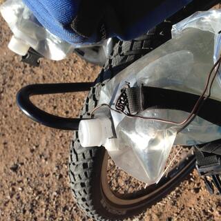 A length of copper wire attached to the neck of a collapsible water bottle.