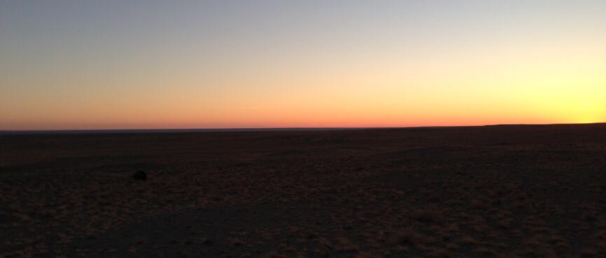 Black earth contrasts with a blue orange gradient sky.