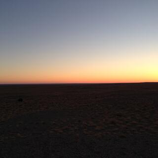 Black earth contrasts with a blue orange gradient sky.