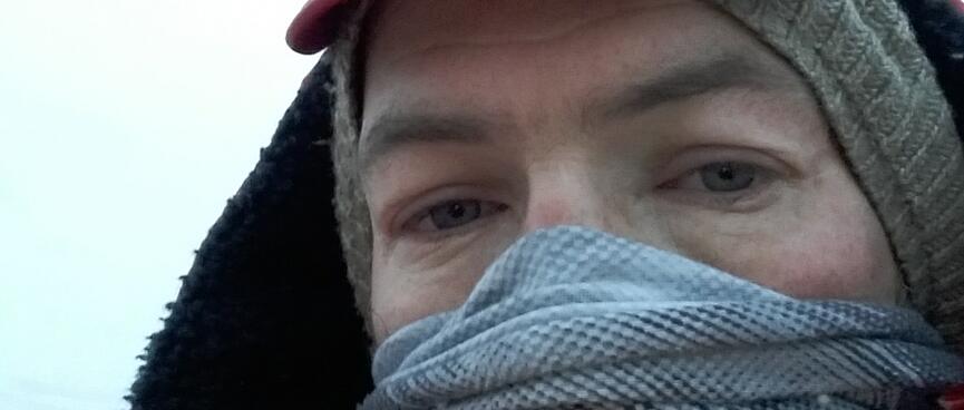 Dressed in 2 hats, a face Buff and a puffer jacket, my eyes hold a blank stare.