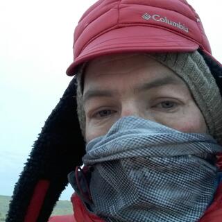 Dressed in 2 hats, a face Buff and a puffer jacket, my eyes hold a blank stare.