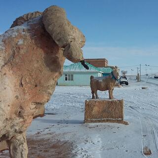 Concrete statues of a sheep and a goat.