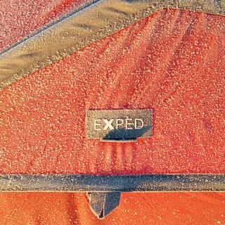 Frozen snow surrounds the EXPED logo on a panel of my tent.