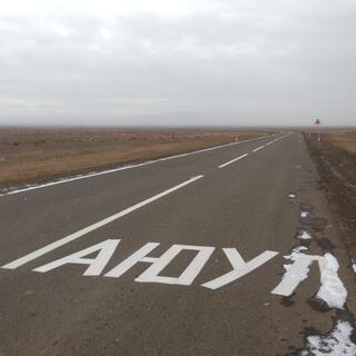 A foreign sign on the asphalt appears to read AHOY.