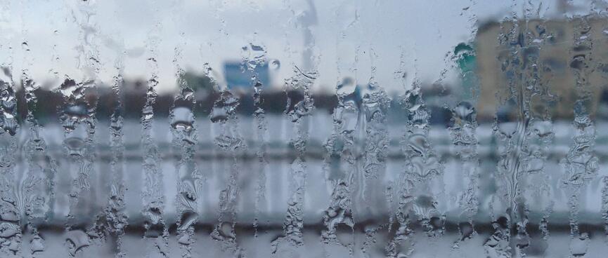 Vertical streaks of condensation obscure the view out the window.
