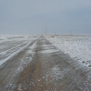 Snow smears on a dirt road resemble the Shroud of Turin.