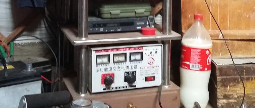 A solar battery meter with Chinese labels sits below a VCR and a widescreen TV.