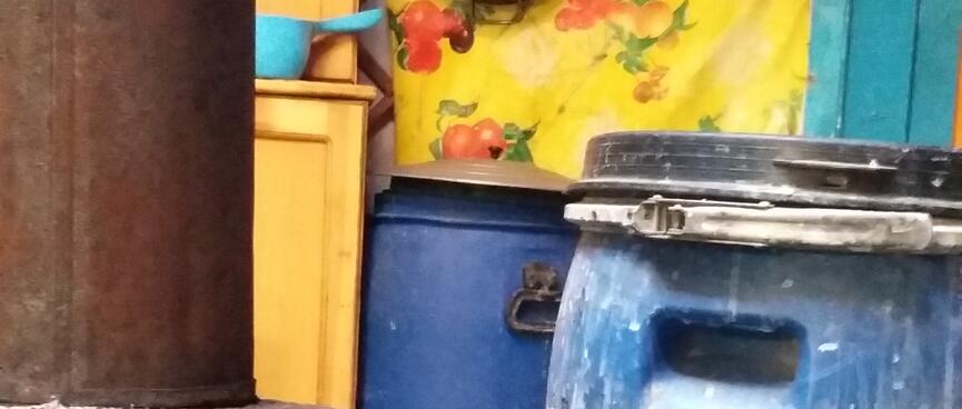 Two large blue barrels stand next to a brown chimney.