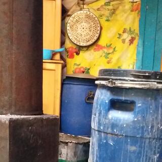 Two large blue barrels stand next to a brown chimney.