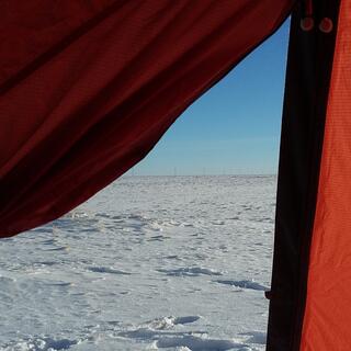 Blue sky and white snow as seen from the tent doorway.