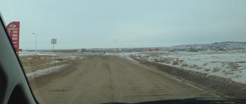 A cluster of low rise buildings and cabins at the end of a dirt road.