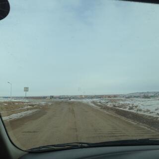 A cluster of low rise buildings and cabins at the end of a dirt road.