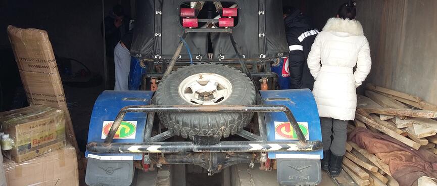 The rear of a raised jeep fitted with roll bars, a spare tyre and  heavy mud guards.
