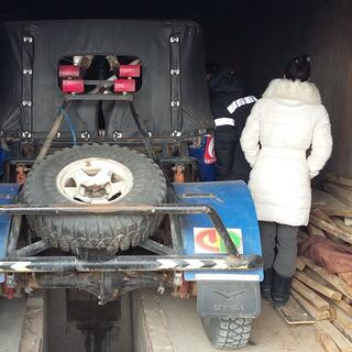 The rear of a raised jeep fitted with roll bars, a spare tyre and  heavy mud guards.