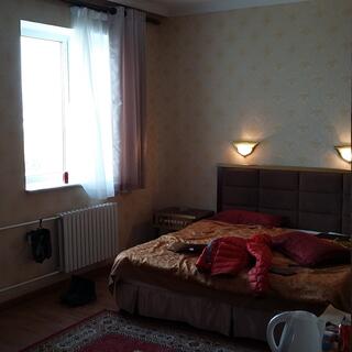 A double bed with a gold bedspread in a dimly lit hotel room.