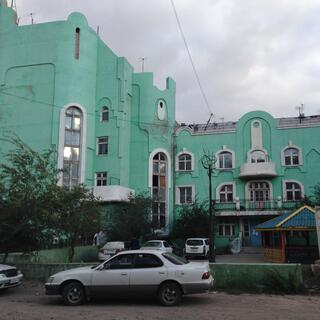 A three story apartment block with interesting arched windows, in Zabaikalsk.